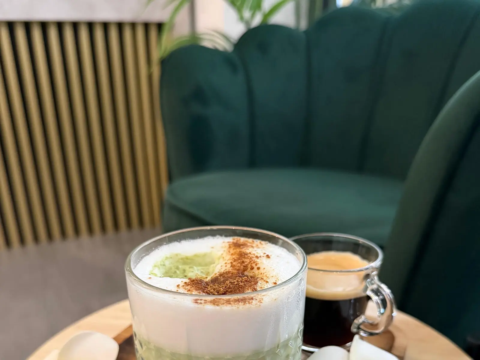 Green velvet chair and drinks on a small table in a lounge area