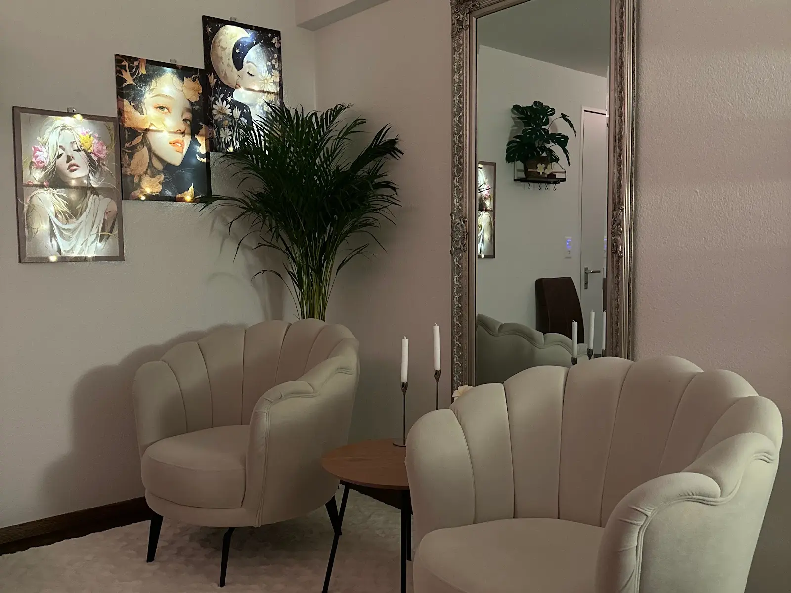 Elegant massage waiting area with beige chairs, mirror, plant, and wall art