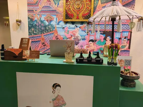 Colorful Thai spa reception desk with ornate mural and decorative accents