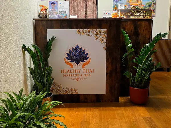 Spa reception desk with plants and Healthy Thai Massage sign
