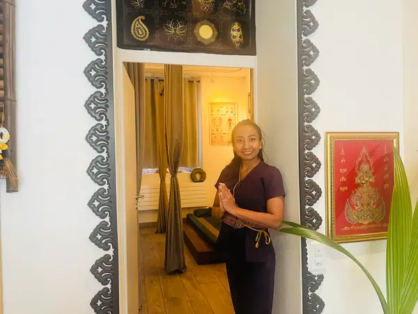 Thai massage salon entrance with ornate decor and smiling attendant