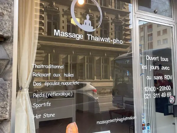 Massage Thai massage salon storefront with window text and reflections on the glass