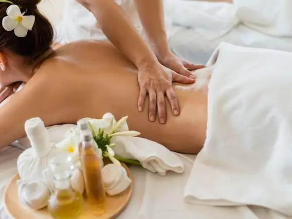 Massage therapist working on a client in a bright spa treatment room