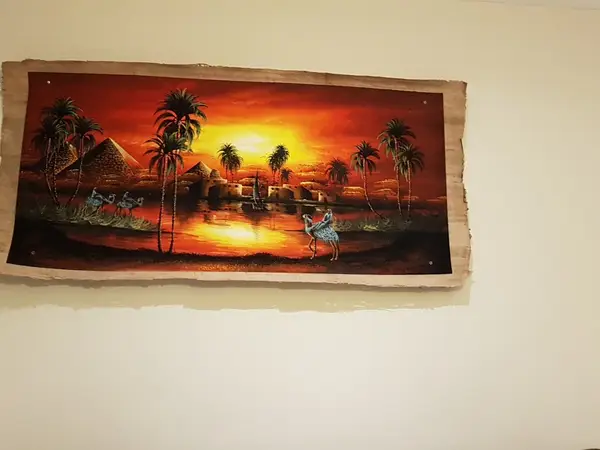 Framed sunset landscape artwork on a cream wall