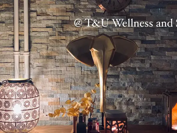 Decorative spa reception with stone wall, elephant sculpture, lanterns, and warm lighting