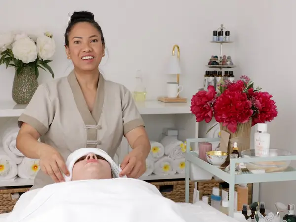 Massage therapist treating a client in a bright, neatly arranged treatment room