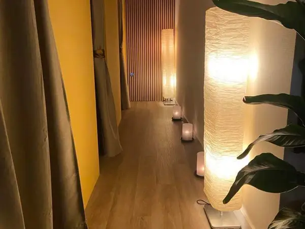 Dim spa hallway with curtains, lanterns, and warm lighting