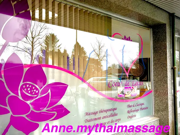 Exterior storefront window with pink lotus graphics and massage service text