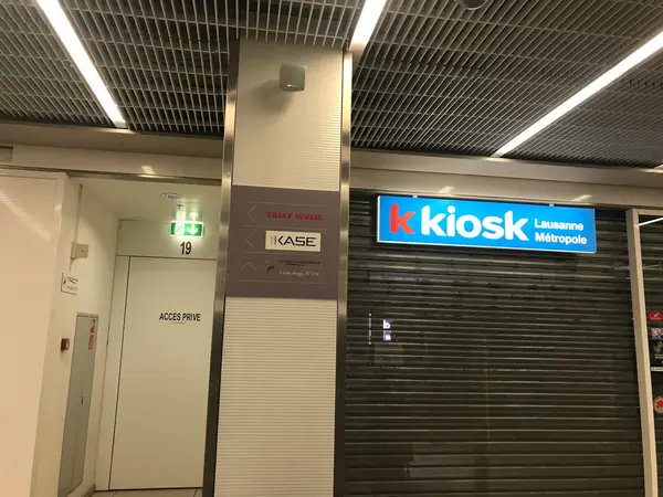 Indoor shopping arcade with a closed kiosk storefront and private door nearby