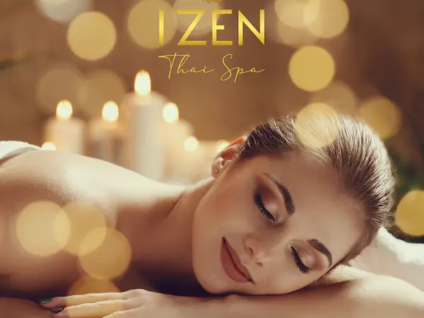 Relaxed woman lying face down in a warmly lit spa setting with candles