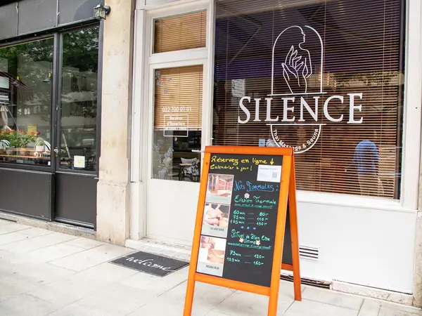 Streetfront Thai massage salon with window logo and orange sidewalk chalkboard sign