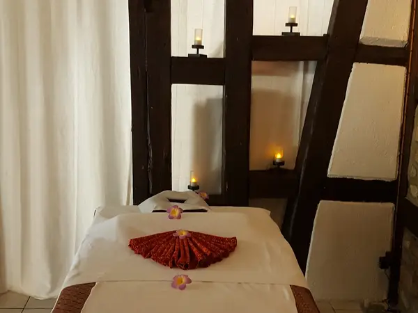 Dim massage room with treatment table, candles, and white curtains