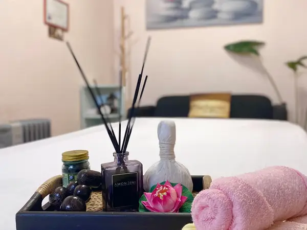 Massage room with white table, tray of spa items, and pink towels
