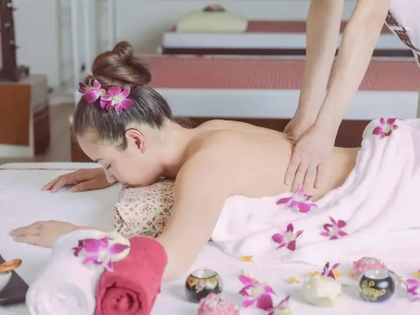 Massage room with a woman receiving a back massage on a treatment bed