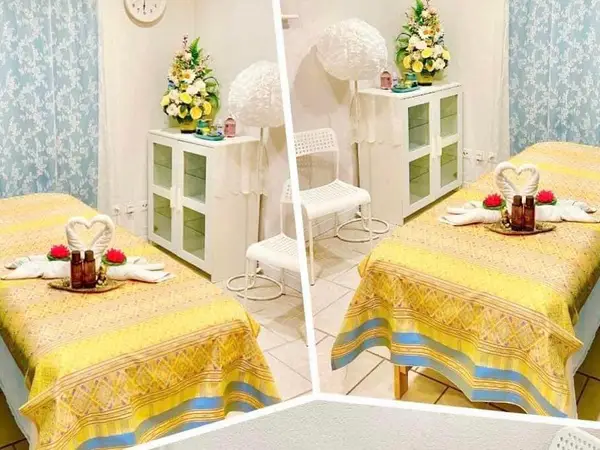 Bright Thai massage room with twin yellow-covered treatment beds and white decor