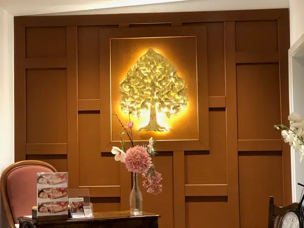 Warm salon reception with glowing tree wall art and pink flowers