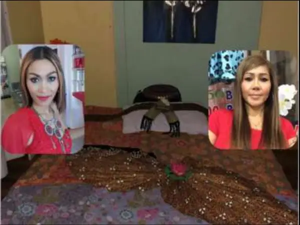 Dim massage room with a decorated bed and two portrait photos on screen
