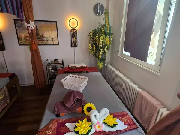Cozy massage room with two tables, warm lighting, and floral decor