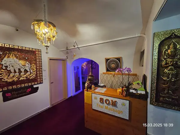 Decorative Thai massage reception with warm lighting and ornate wall art
