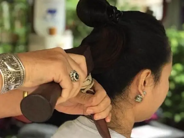 Close-up of a shoulder massage with a woman seated indoors