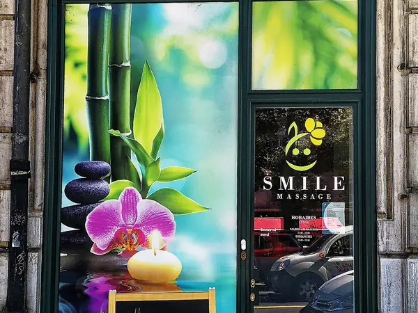 Exterior storefront with bamboo, orchid, and Smile Massage signage