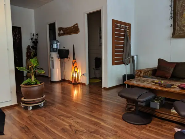 Warm Thai massage waiting room with wood floors, plants, and woven seating