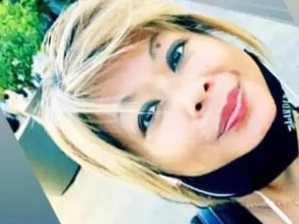 Close-up selfie of a woman outdoors, slightly tilted