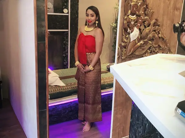 Decorated massage room with a woman in traditional dress and purple lighting