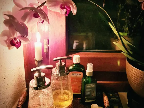 Warmly lit spa counter with orchids, candles, and massage oils