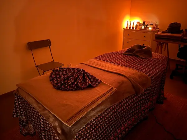 Dim Thai massage treatment room with a covered table and warm lighting