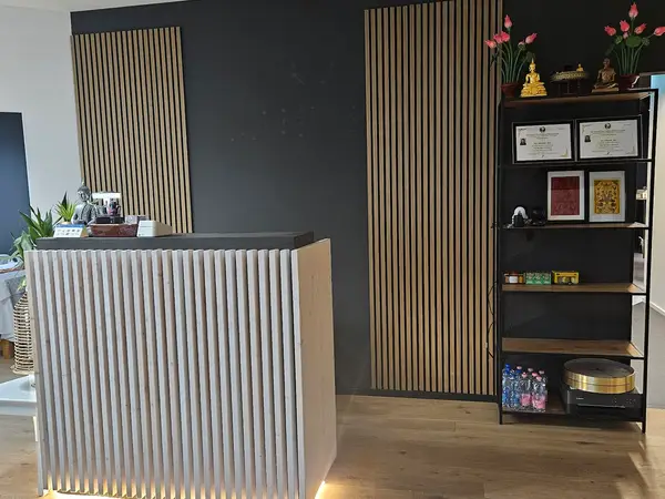 Modern massage reception with slatted wood decor and a shelving display