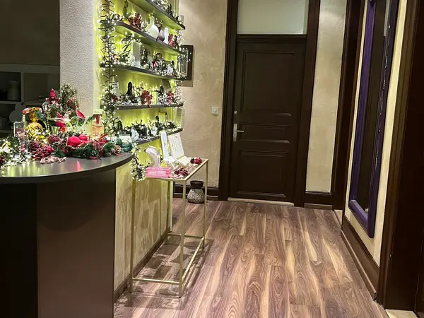 Decorated hallway with shelves, flowers, and a closed wooden door