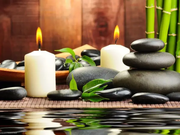 Spa still life with candles, stacked stones, bamboo, and leaves