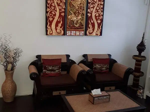 Thai massage waiting area with two armchairs, decor, and a low table