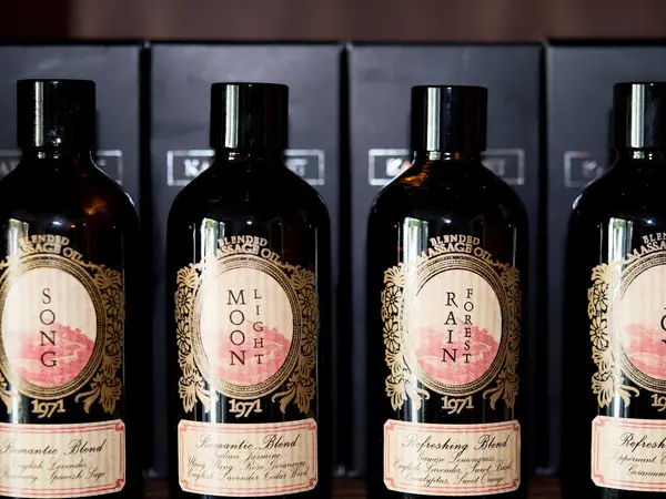 Shelves of massage oil bottles with ornate labels in a dim salon interior