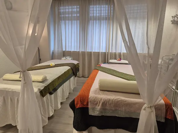 Two massage tables in a softly draped, bright treatment room