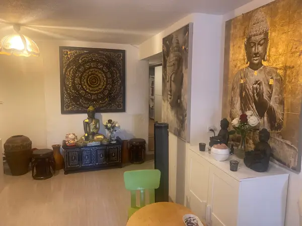Warm Thai massage reception room with Buddha decor and golden wall art