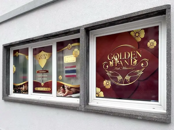 Exterior storefront windows with Golden Hand Thaï Massage signage and open notice