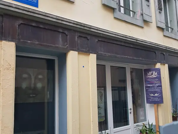 Exterior storefront of a Thai massage salon with glass doors and purple signboard