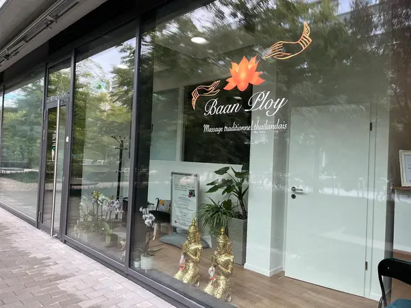 Exterior storefront with glass windows, Thai decor, and gold Buddha statues inside