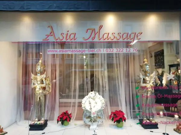 Exterior storefront of Asia Massage with gold statues and sheer curtains