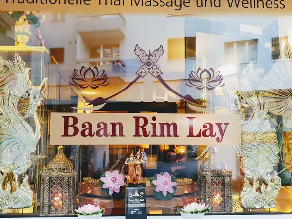 Decorative Thai massage salon window with Baan Rim Lay sign and ornate lanterns