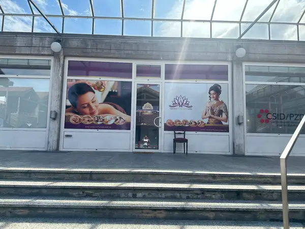 Exterior storefront with Thai massage posters and glass entrance under a canopy