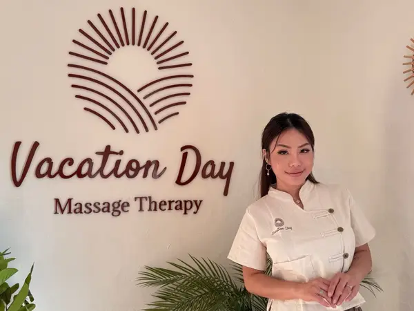 Reception area with logo wall and smiling therapist in white uniform